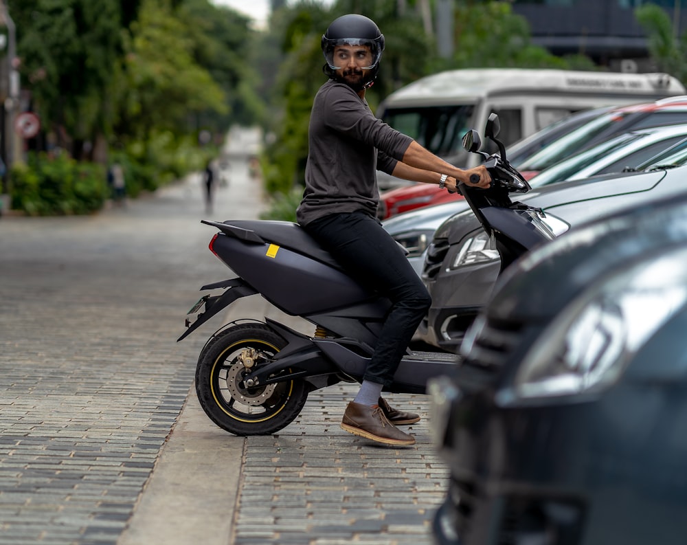 a man sitting on a scooter in a parking lot