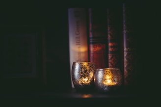 A dark, moody study space with vintage books and a flickering candle.