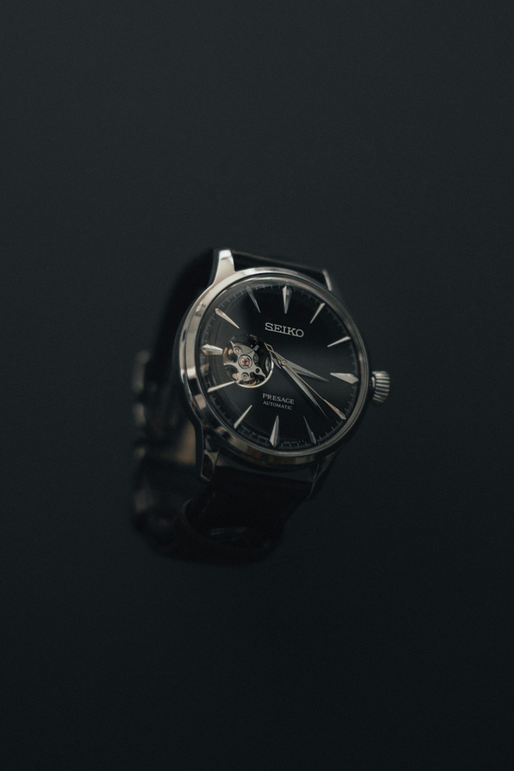 a watch sitting on top of a black surface