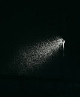 a black and white photo of a street light in the dark