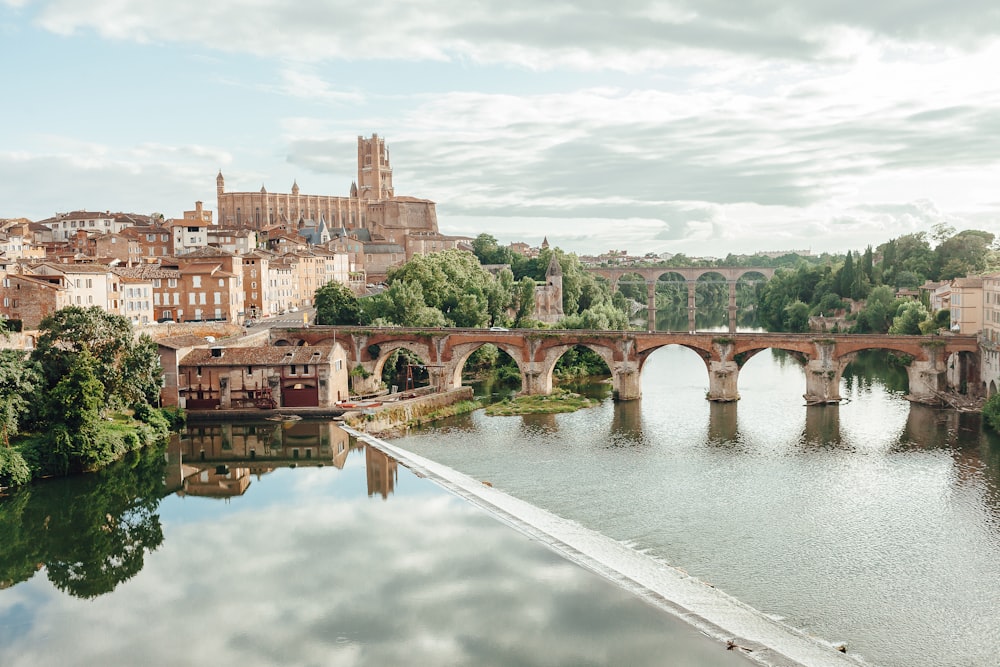 a bridge over a river with a city in the background