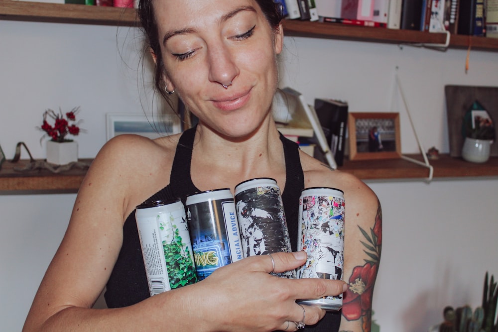 a woman holding two cans of beer in her hands