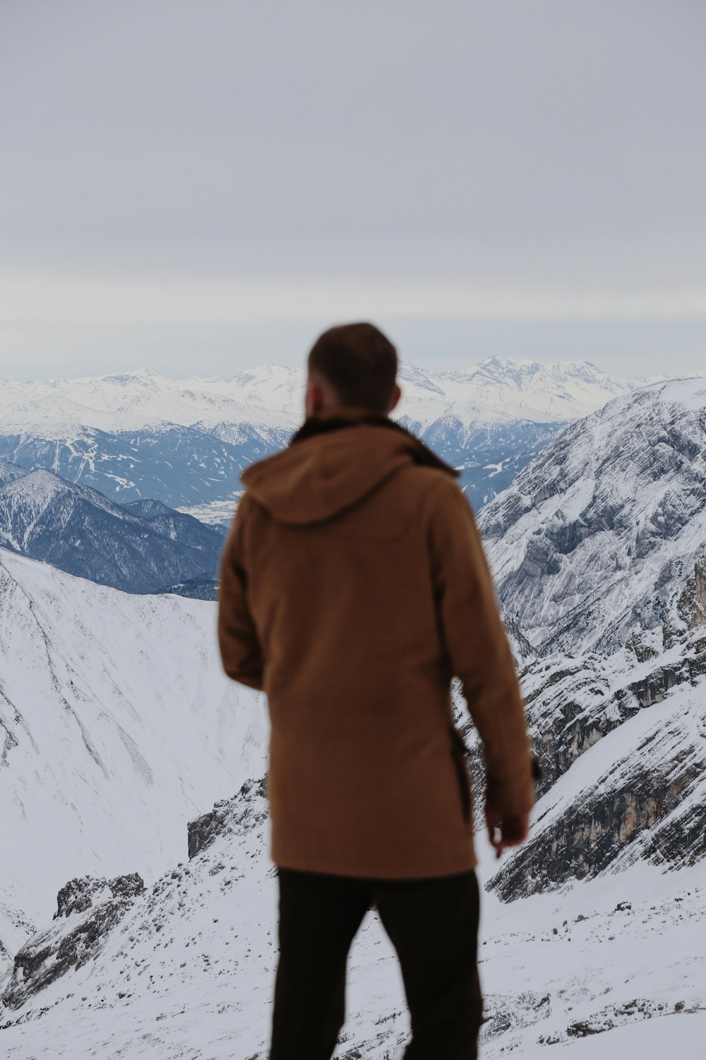 a man standing on top of a snow covered slope