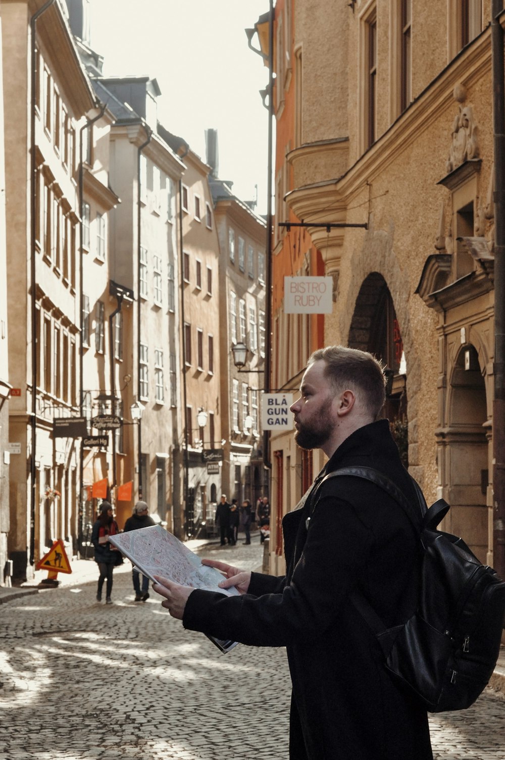 a man standing on a street holding a piece of paper