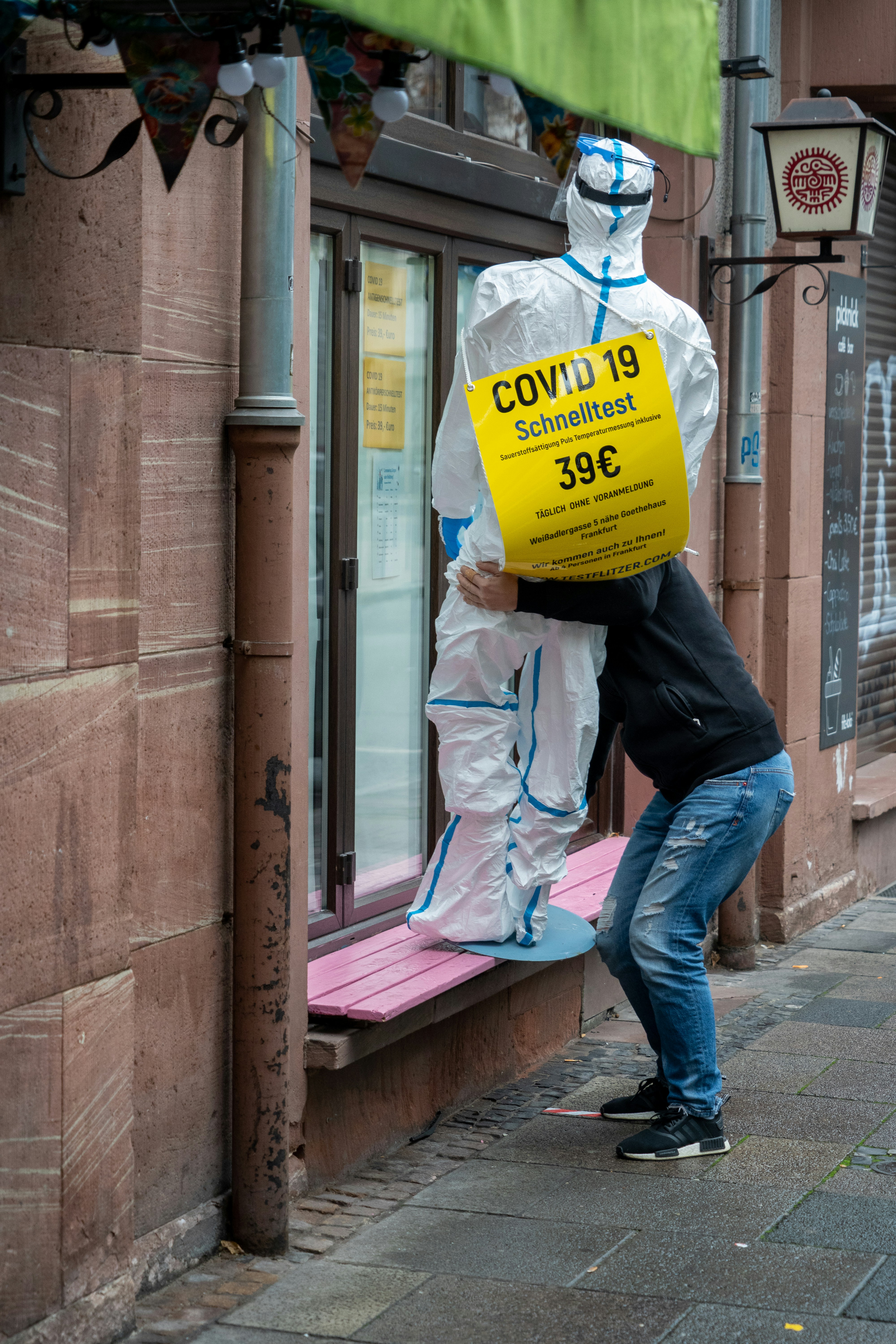 a man with a bag on his head is standing outside of a store