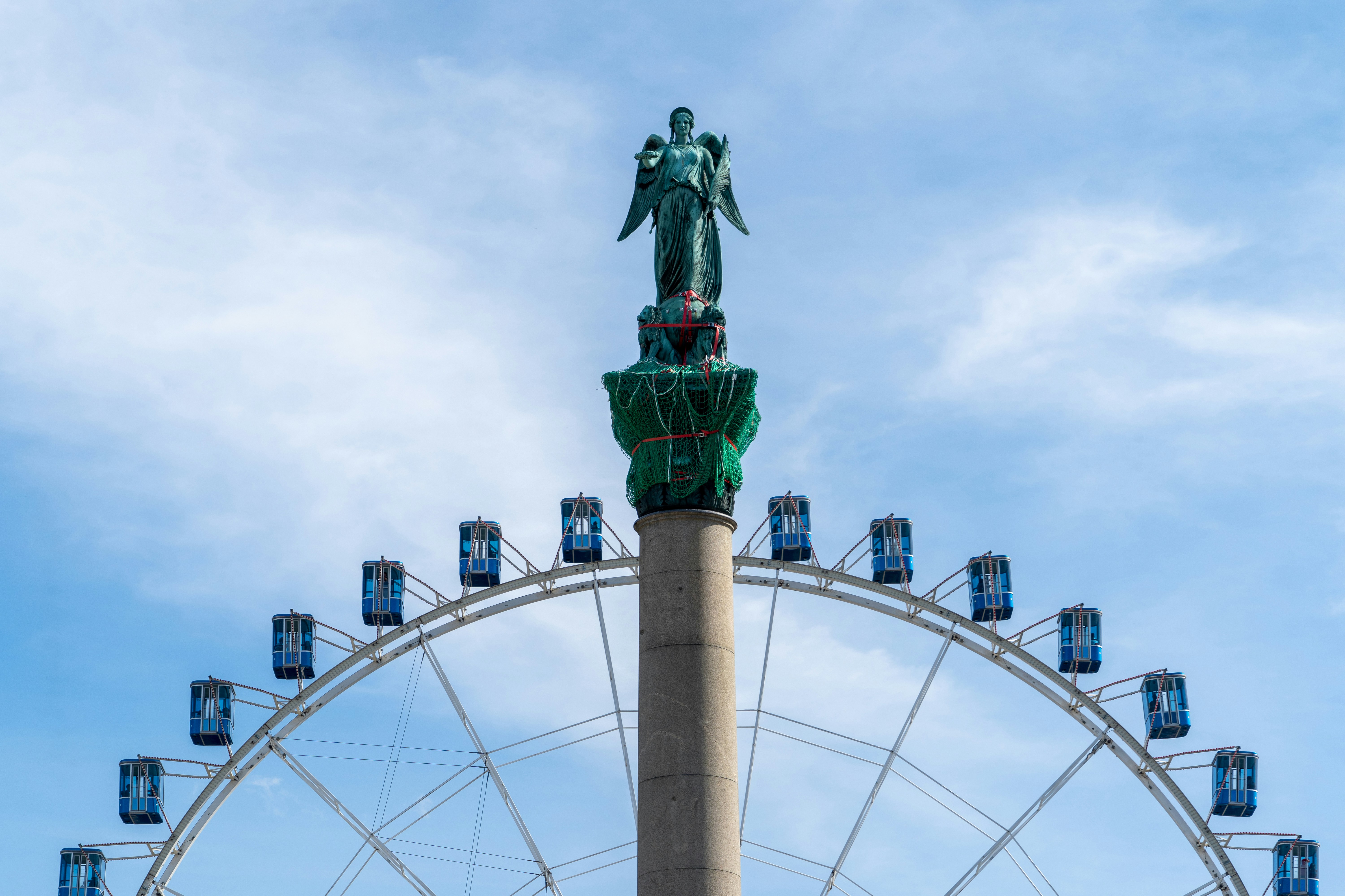 A ferris wheel behind a statue in Stuttgart (Jubiläumssaüle Schlossplatz), Germany, 2021-10-03. There are 35.000+ other free Covid pics at https://CoronaBrowser.com