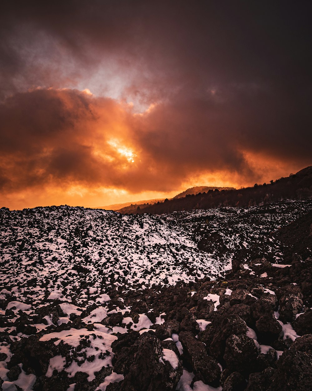 the sun is setting over the rocky terrain