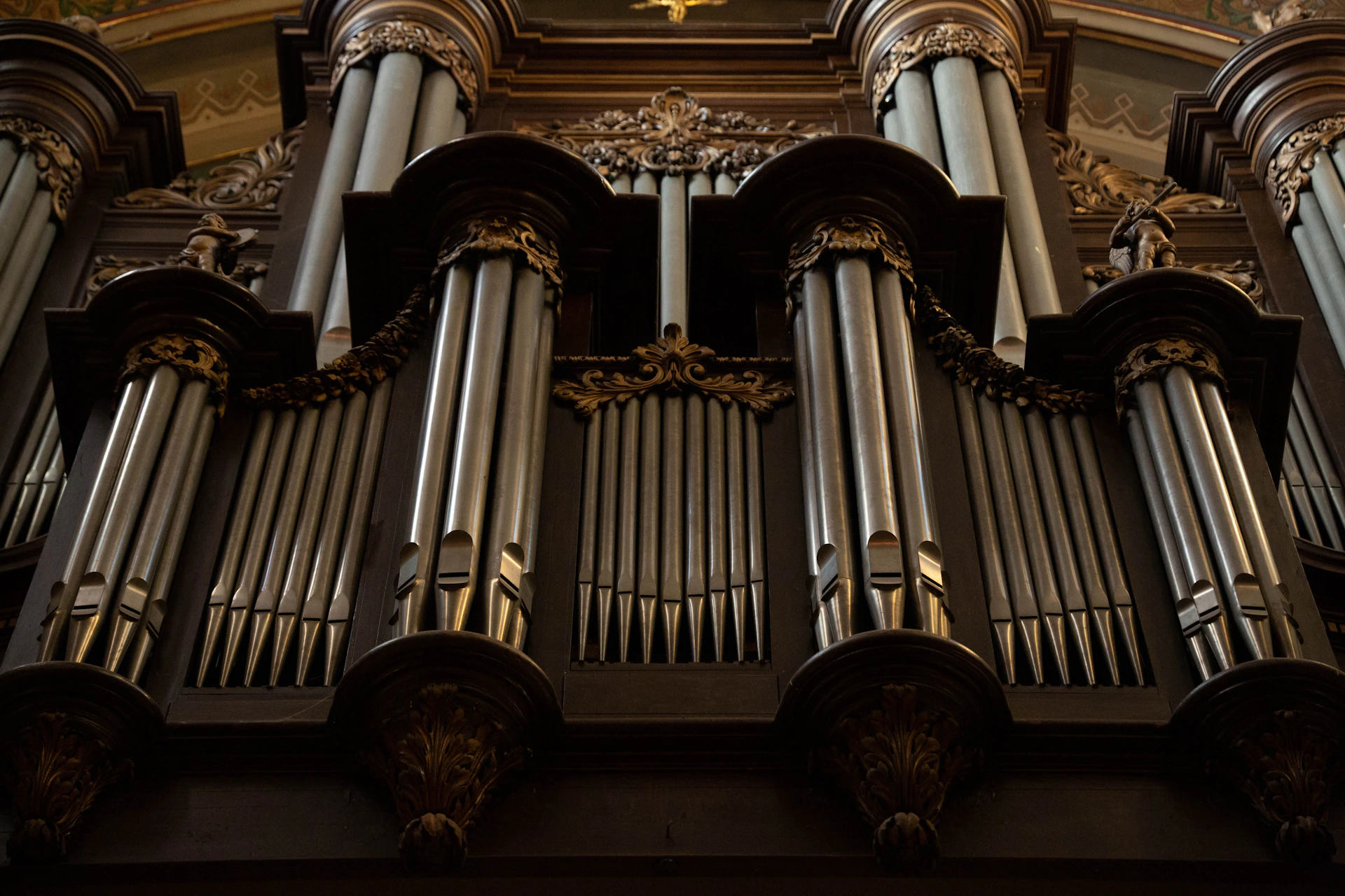 a large pipe organ in a church with a cross above it