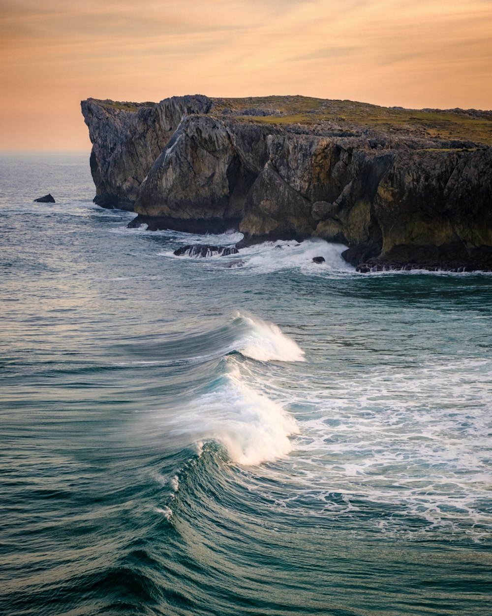 a large body of water next to a rocky cliff