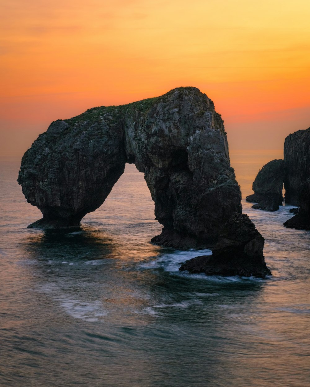 a large rock formation in the middle of the ocean