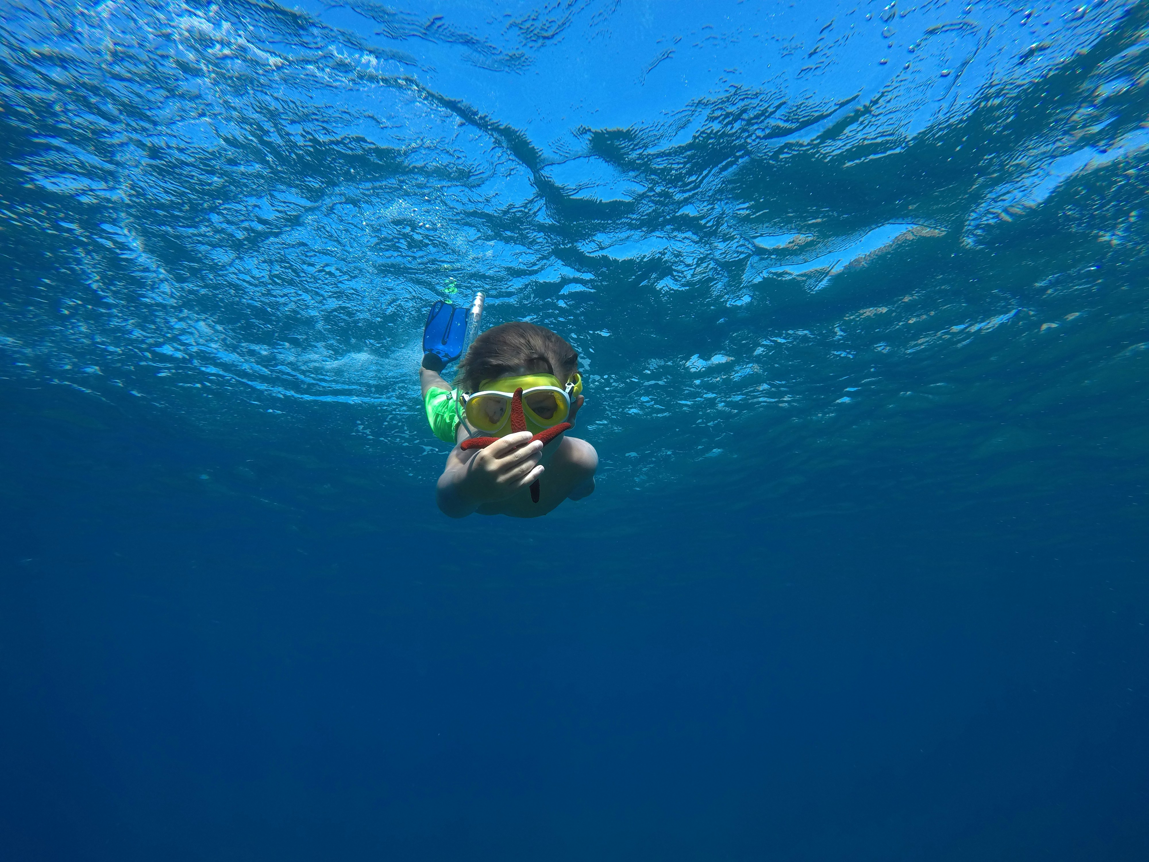 a person swimming in the water with a pair of goggles