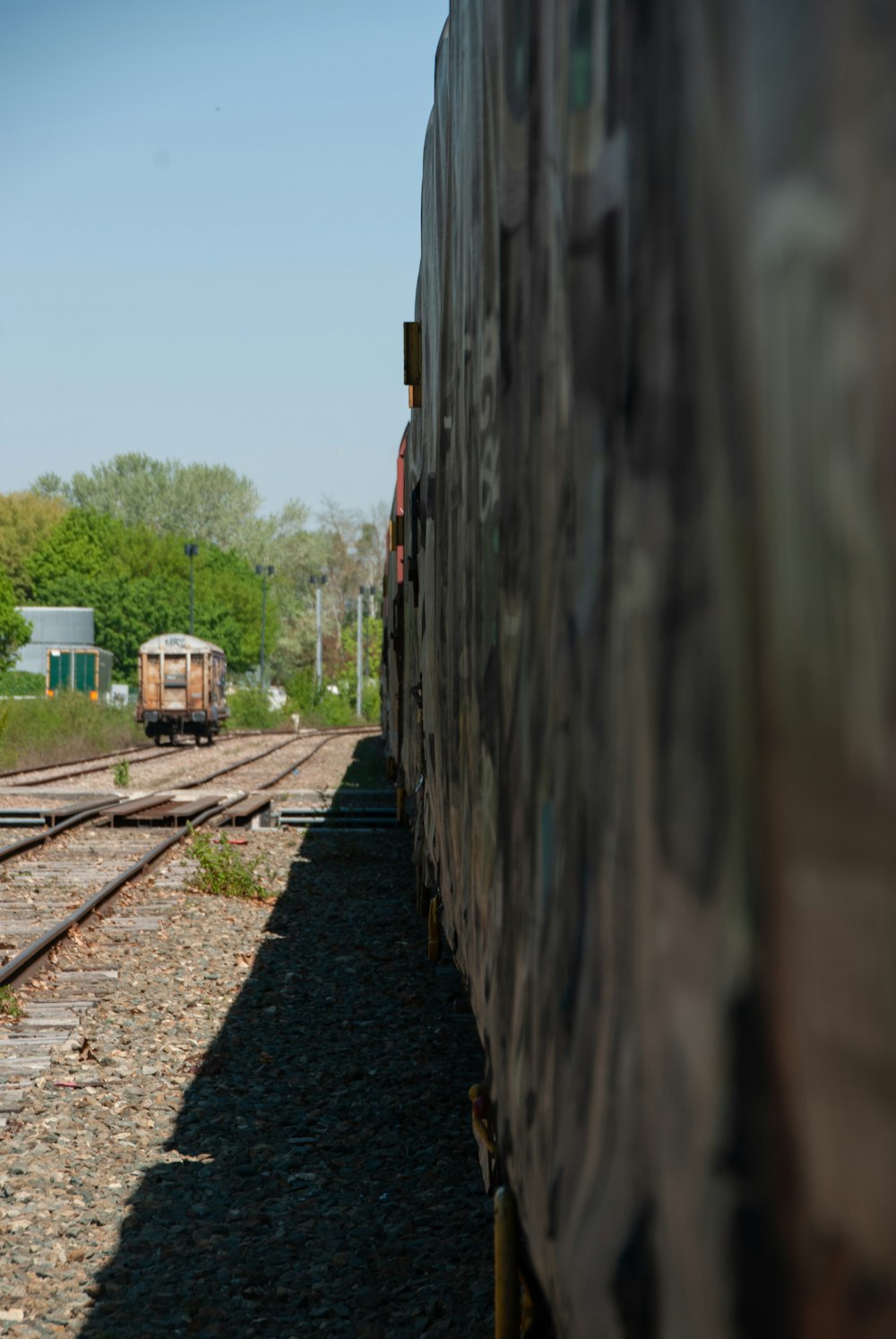 a train traveling down train tracks next to a forest