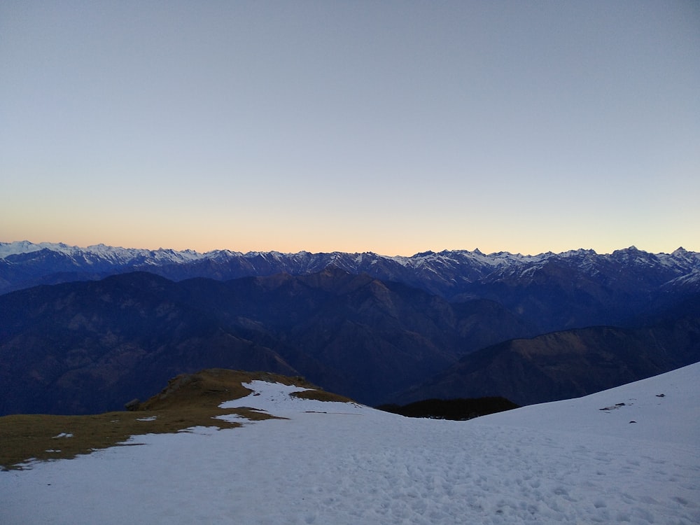 a view of a mountain range with snow on the ground