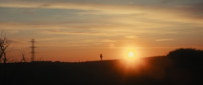 A couple watching a romantic sunset from a hilltop in Kerala.