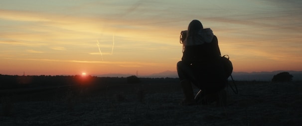 A traveler with a backpack taking in a vast desert landscape at sunrise