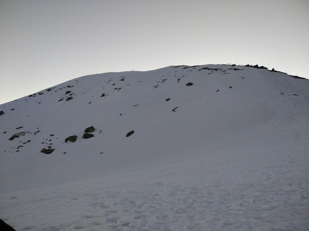 a snowboarder is going down a snowy hill