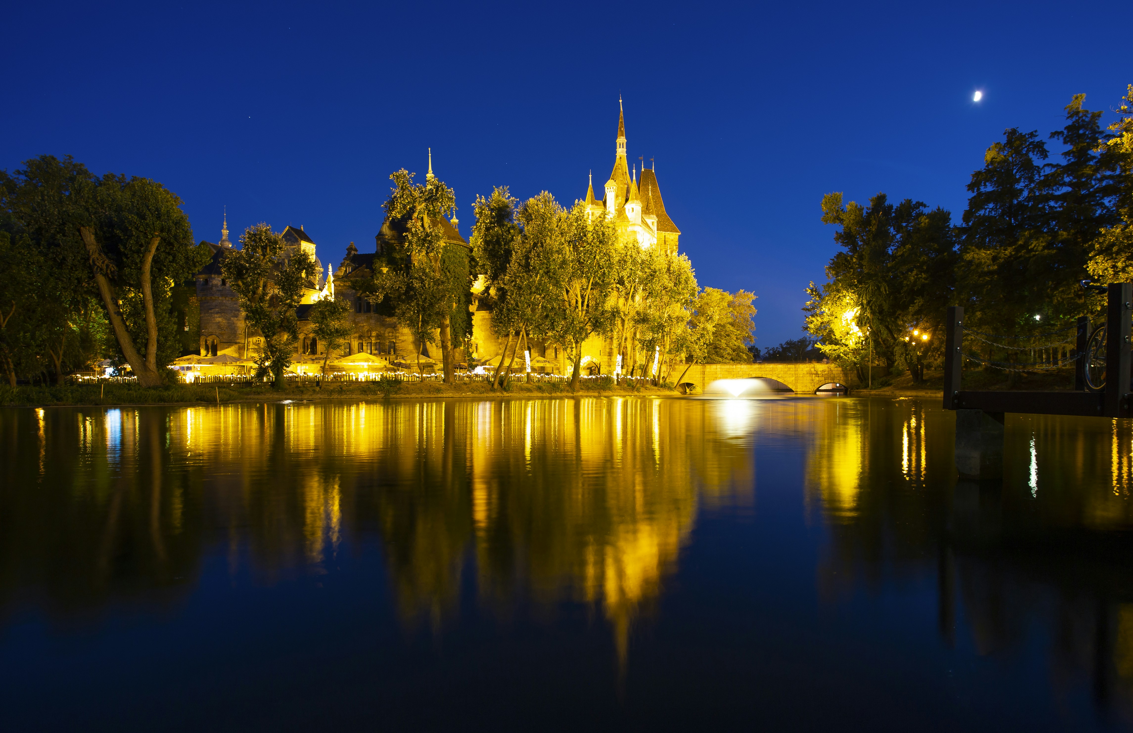 a night scene of a river with a church in the background