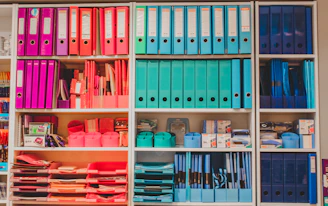 a book shelf filled with lots of books and binders