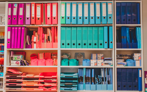 a book shelf filled with lots of books and binders