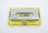 A vintage audio cassette tape with a transparent yellow case and a gray label indicating 'KAMICHI Low Noise High Output' for side B. The cassette tape is labeled with 'LH C90' and features visible reels and spools inside the clear casing.
