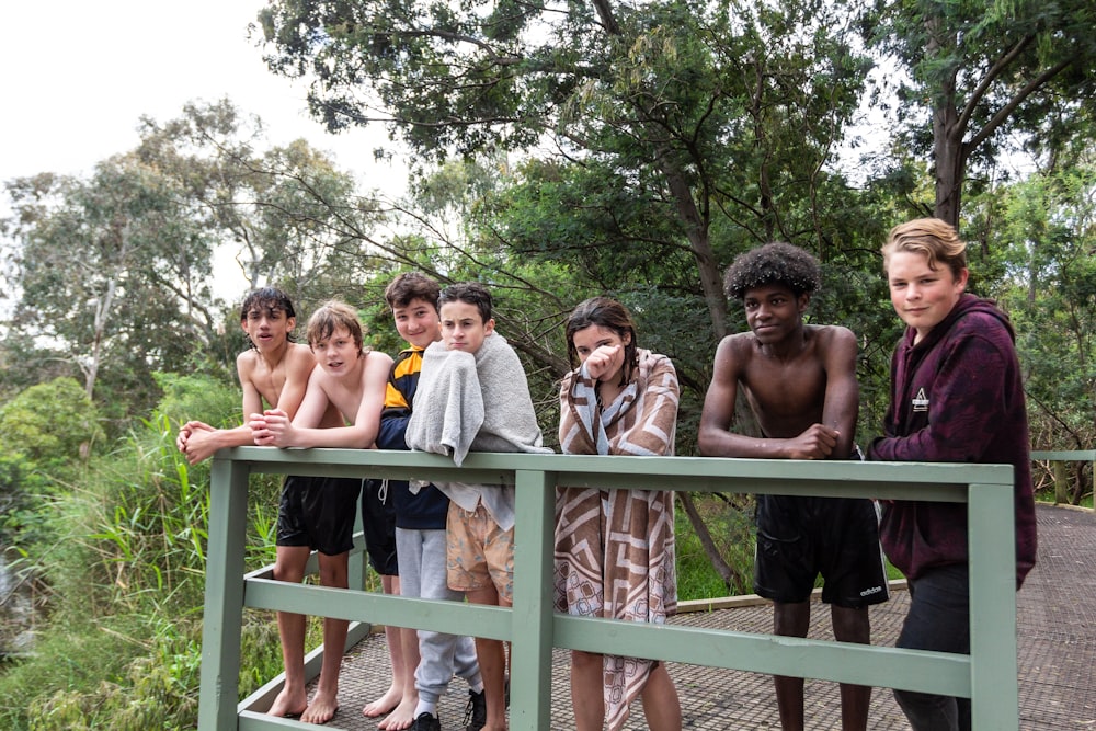 a group of kids standing on a bridge