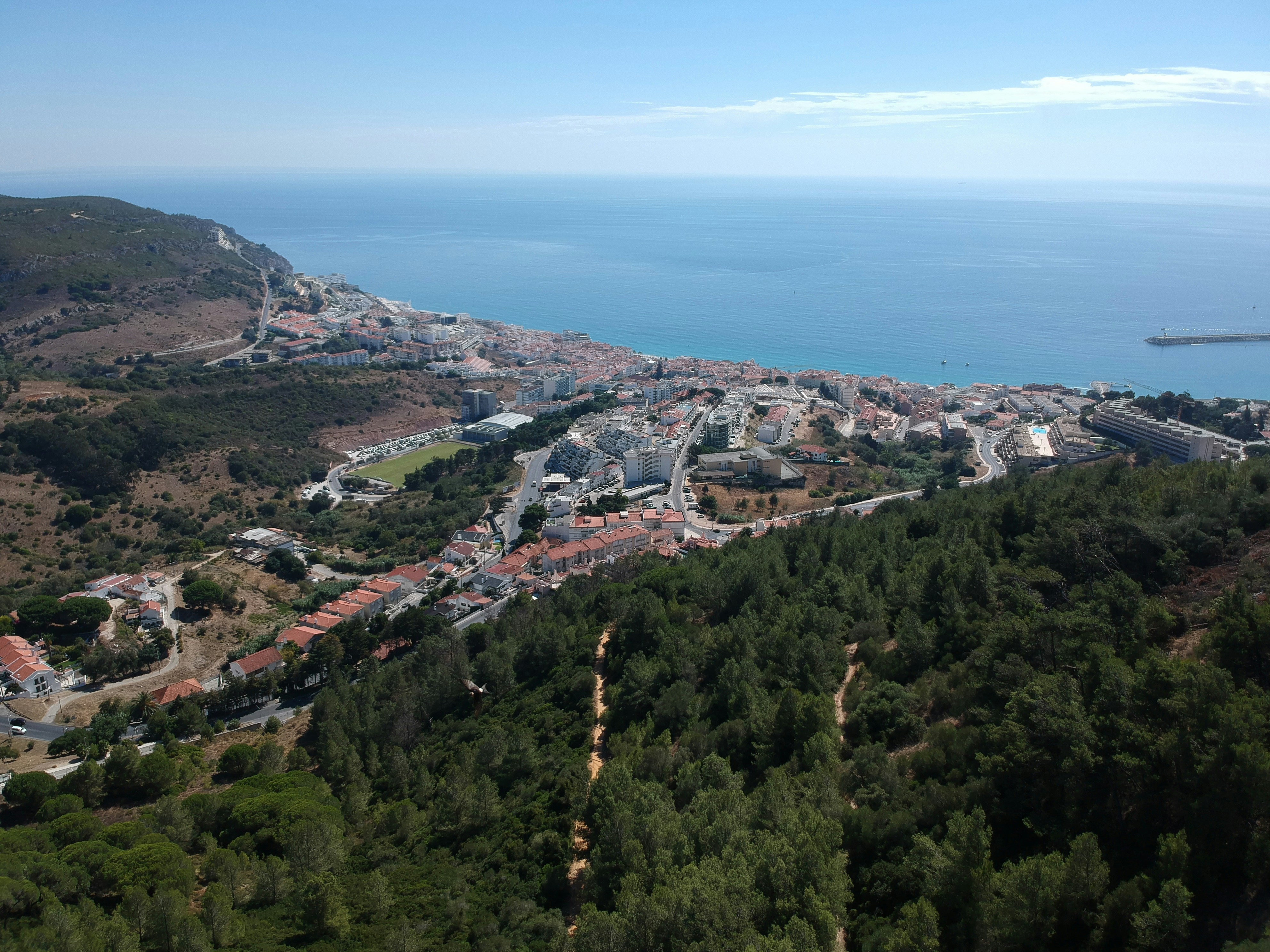 a view of a town and the ocean from a hill