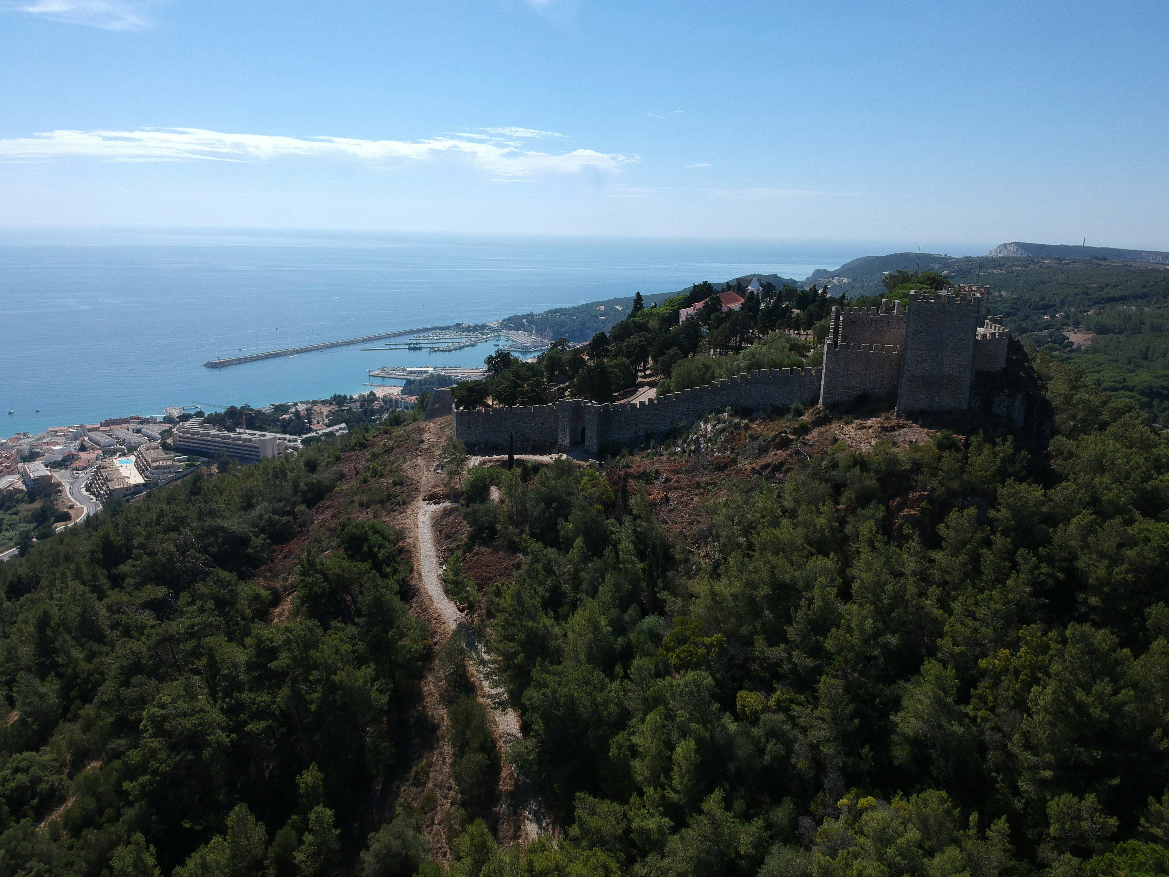 a large castle on top of a hill next to the ocean