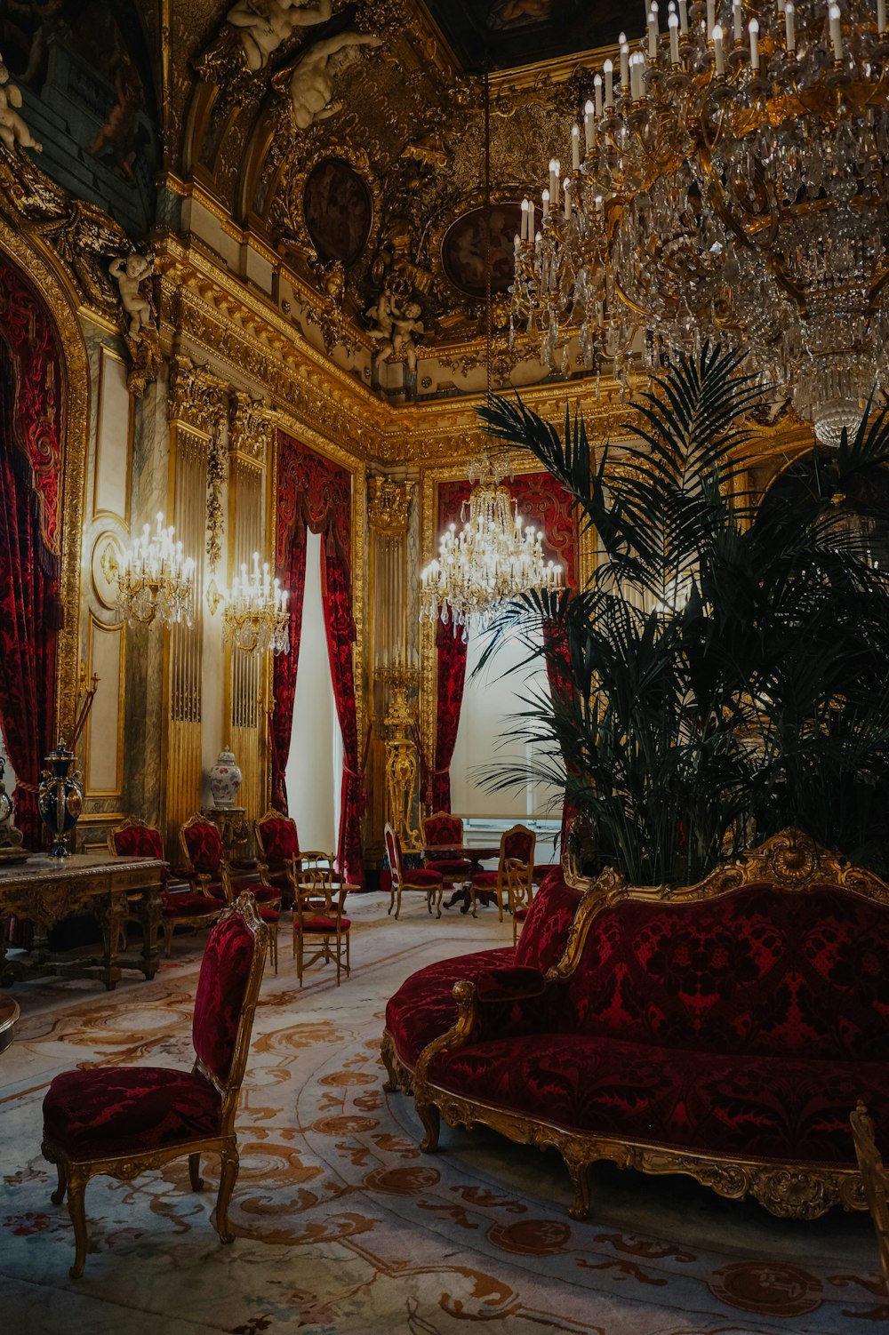 a fancy living room with a chandelier and red couches