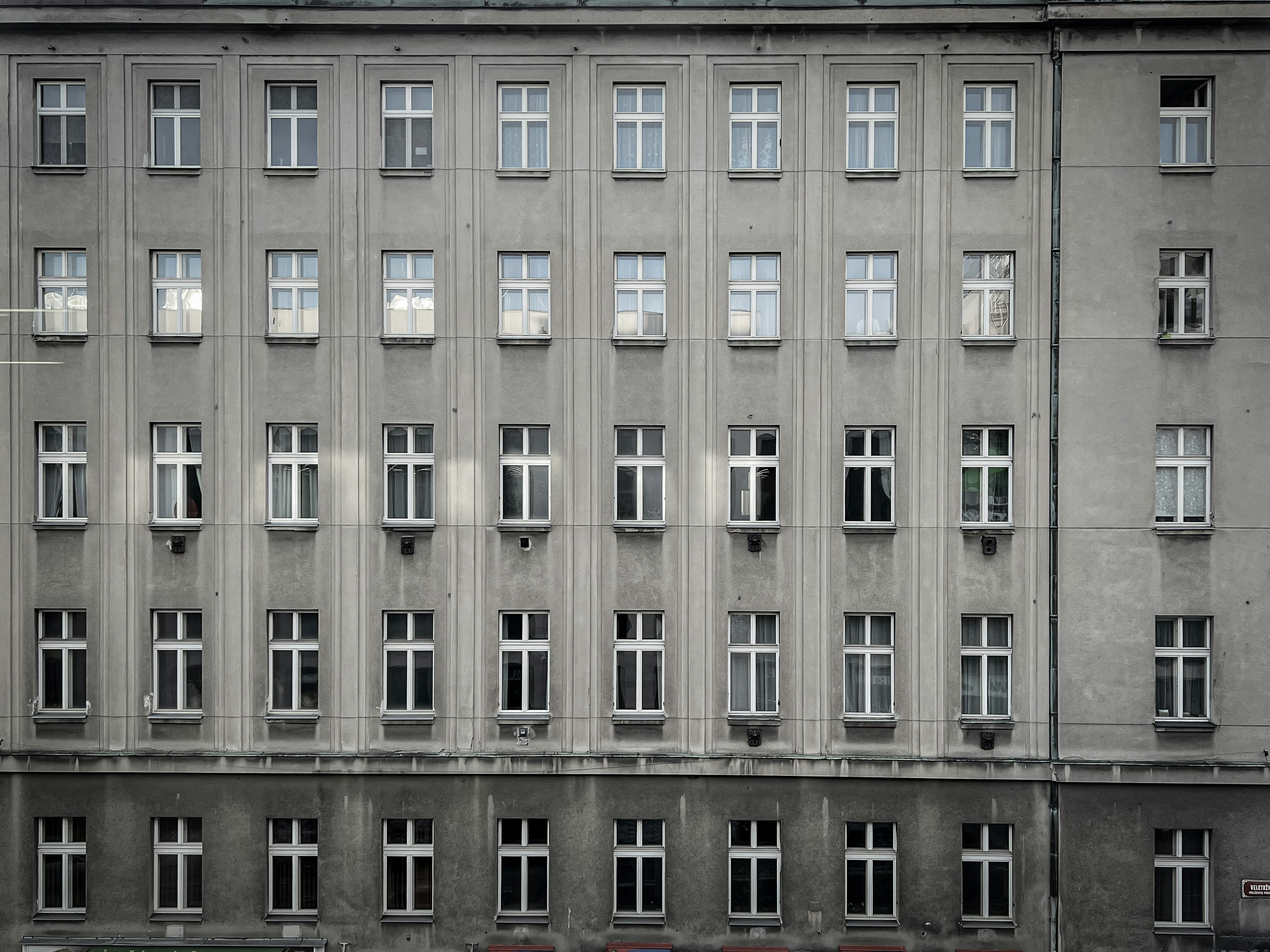 a tall building with many windows and a red car parked in front of it