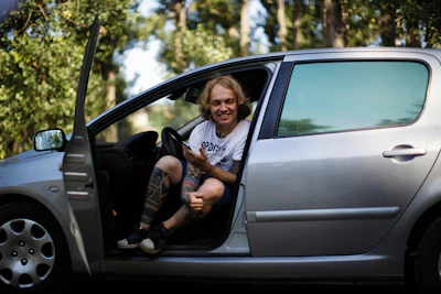 a person sitting in a car with their feet out the window