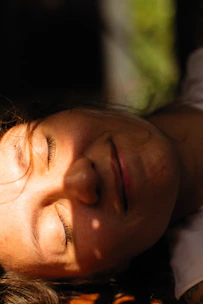 Close-up of a woman enjoying a tanning session with soft golden light highlighting her glowing skin.