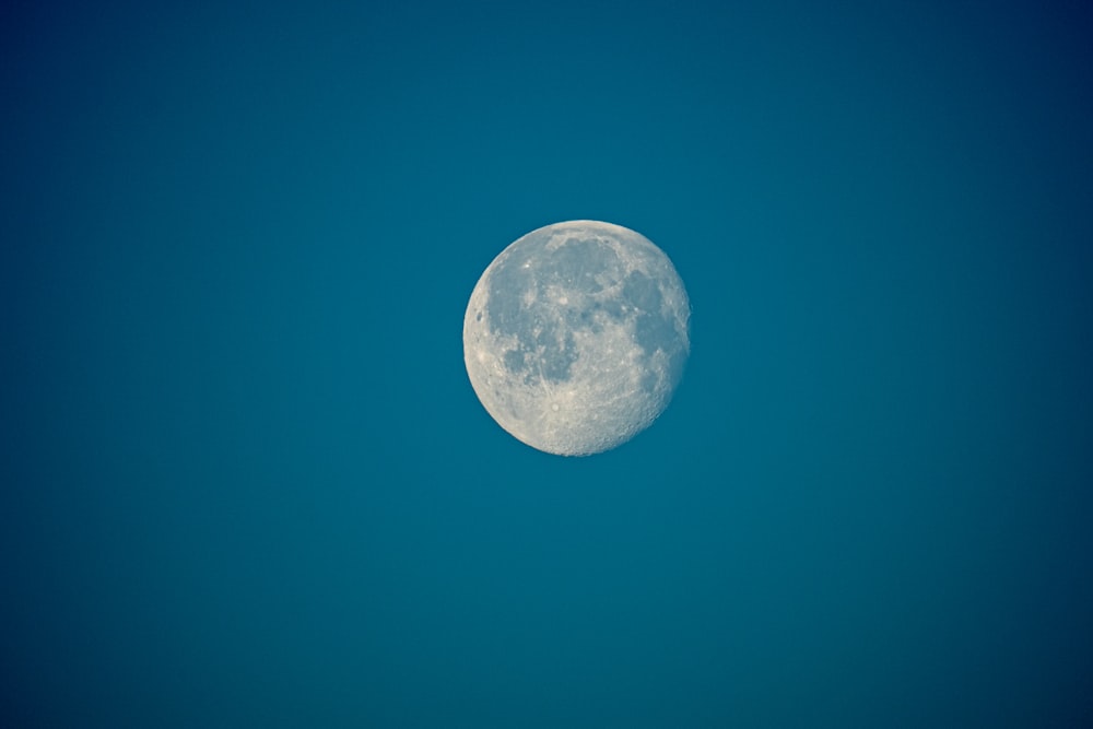 Una luna llena en un cielo azul claro