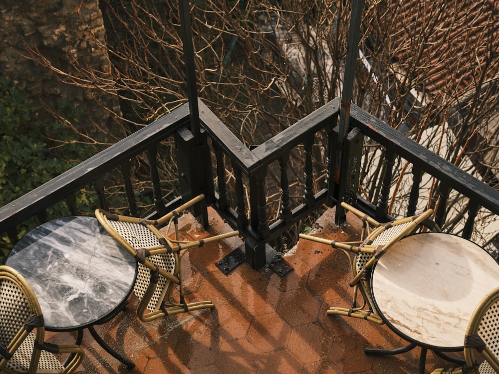 ein paar Tische und Stühle auf einem Balkon