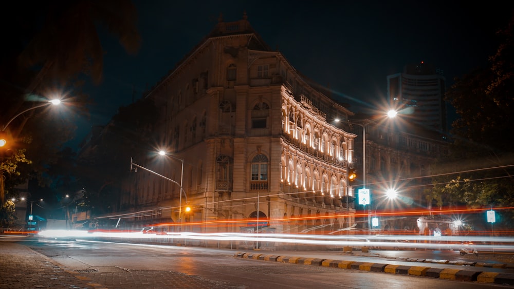 a city street at night with a building in the background