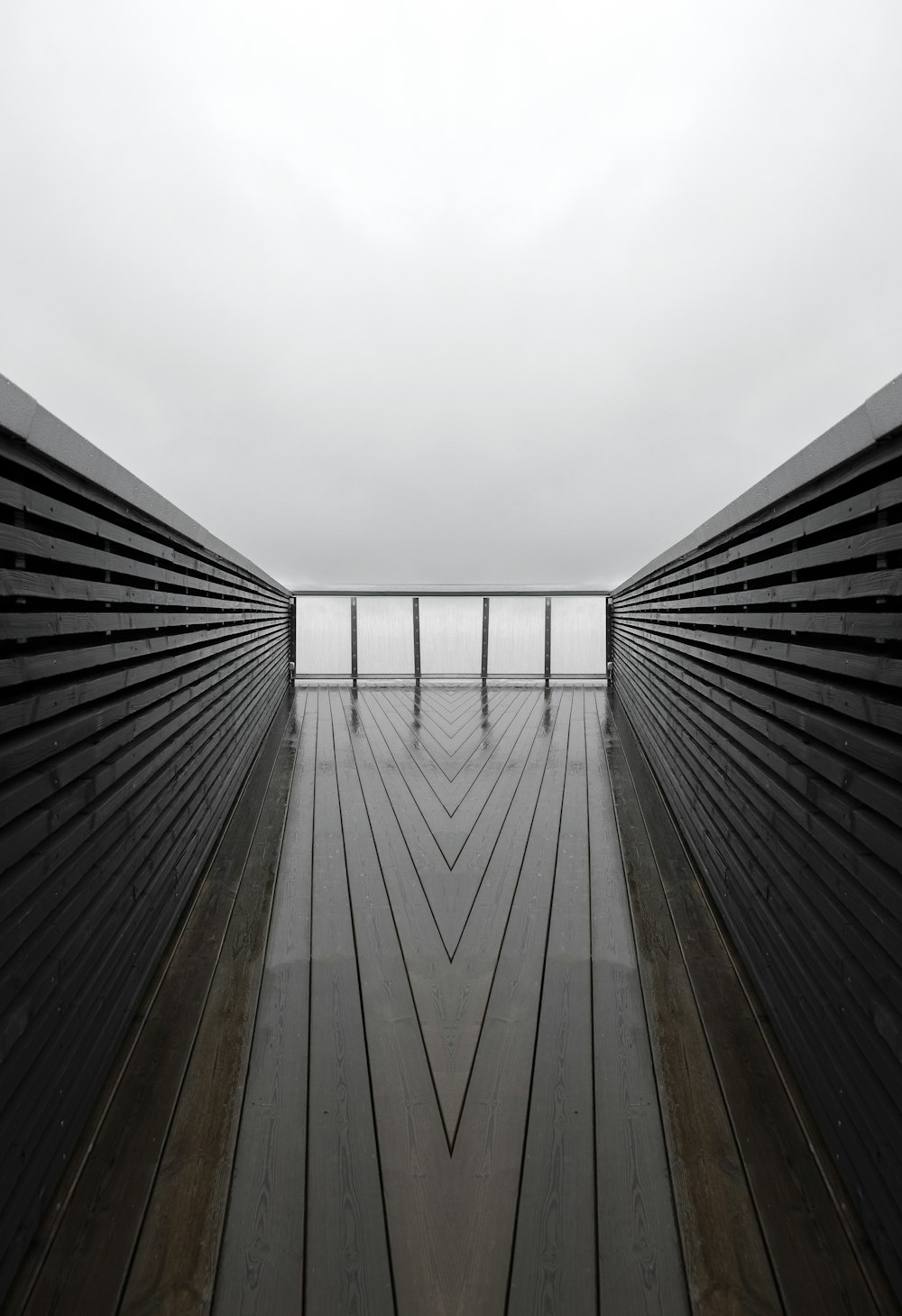 a very long wooden walkway with a view of the ocean