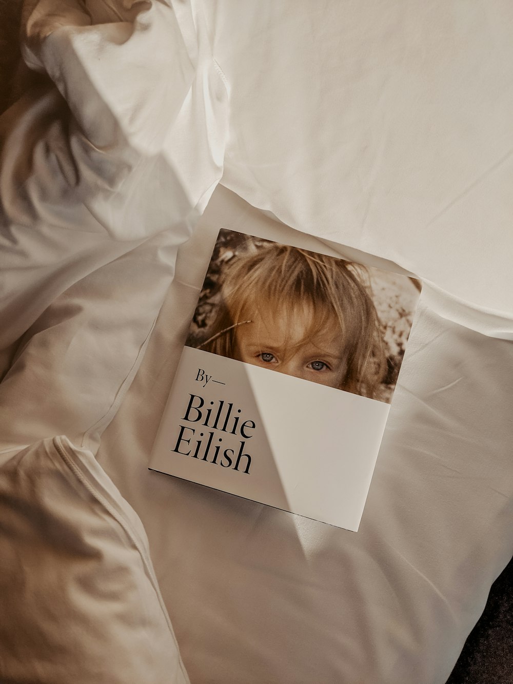 a book is laying on a bed with white sheets