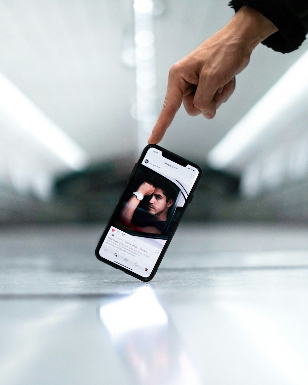 a hand holding a cell phone with a picture of a man on it