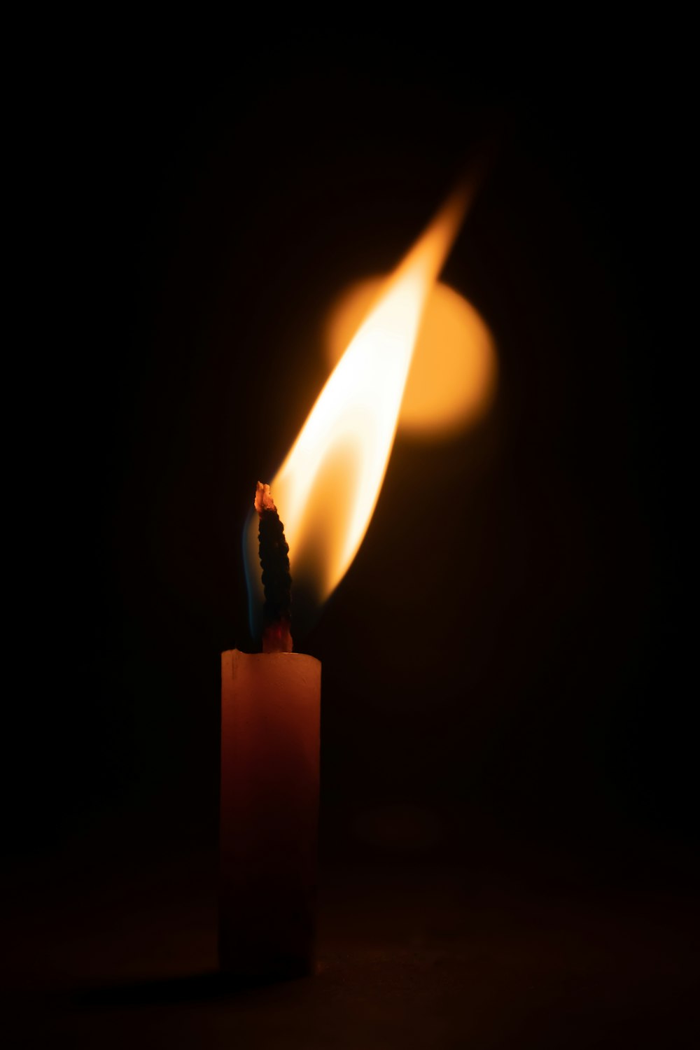 a lit candle with a flame coming out of it