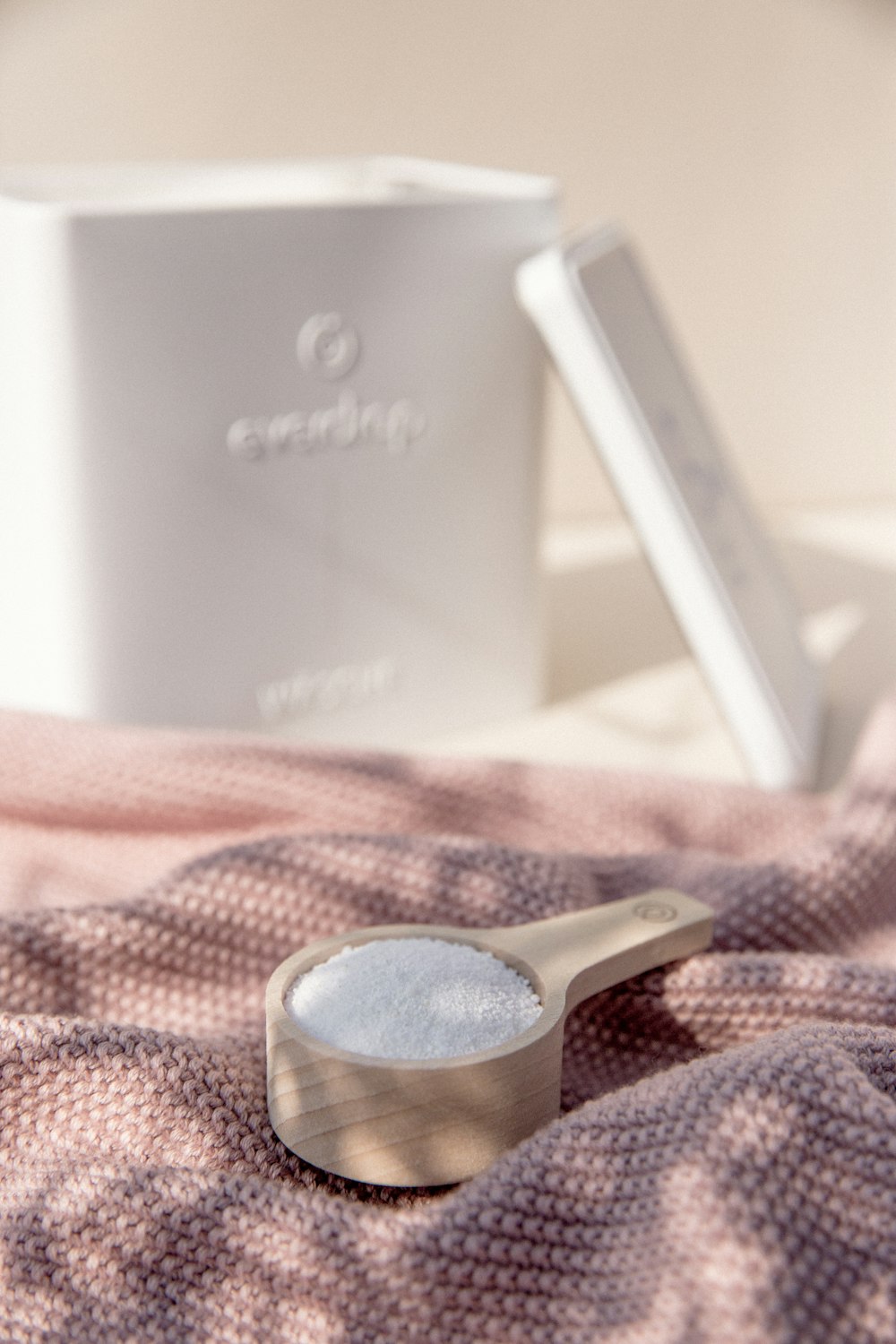 a wooden spoon sitting on top of a pink blanket