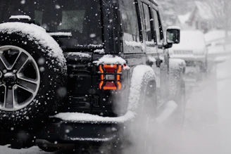 a jeep driving down a snow covered road
