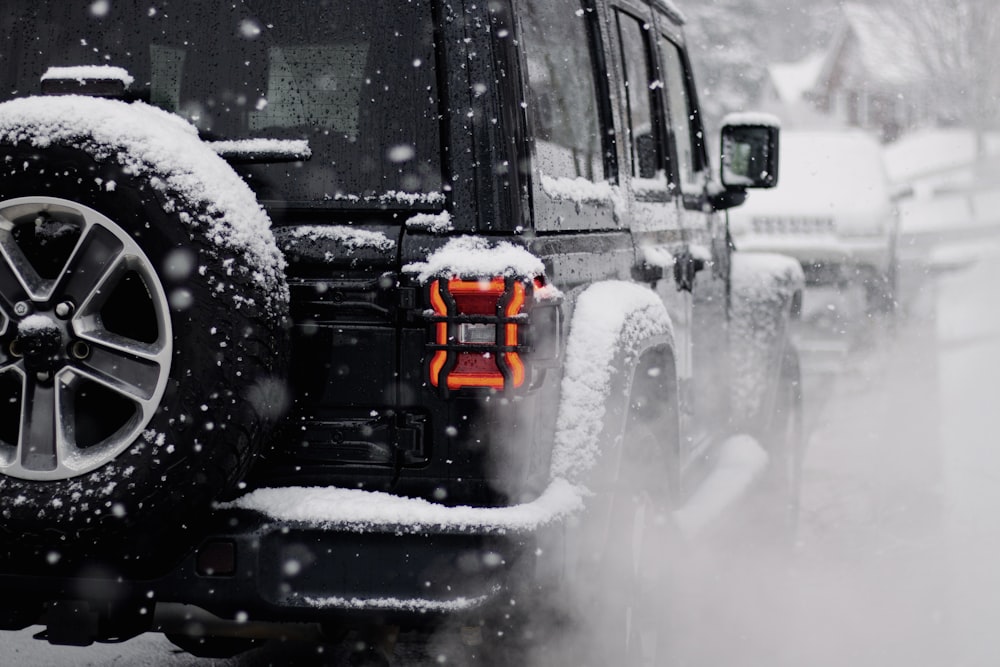 a jeep driving down a snow covered road