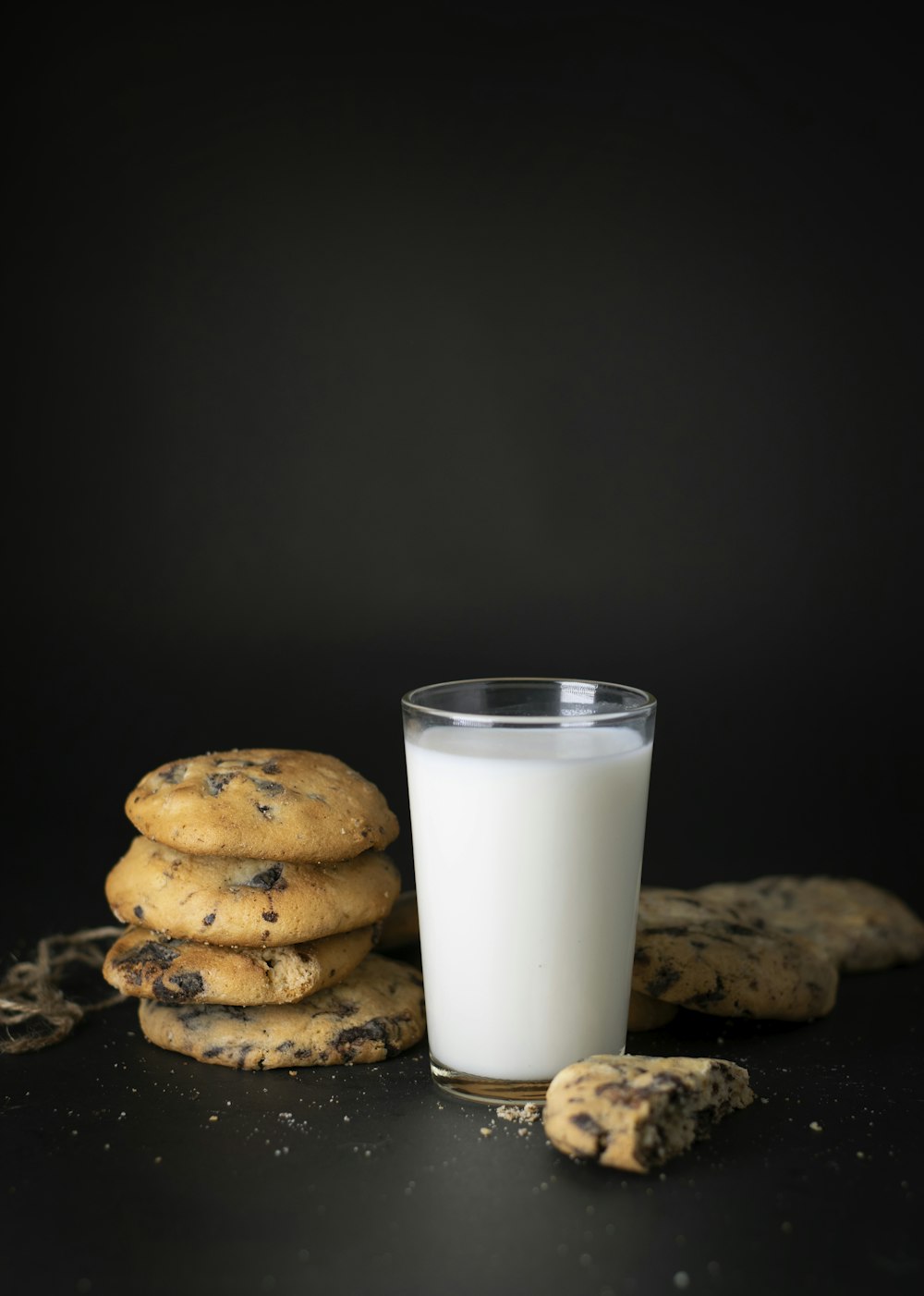 Un vaso de leche junto a una pila de galletas