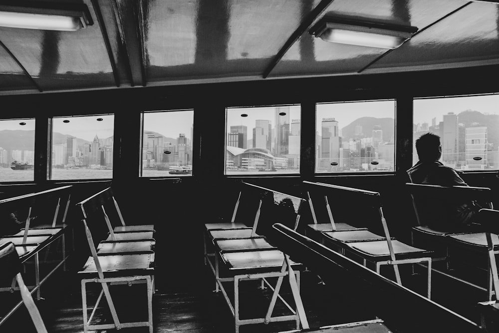 a black and white photo of a person looking out a window