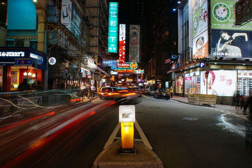 a city street at night with cars and neon signs