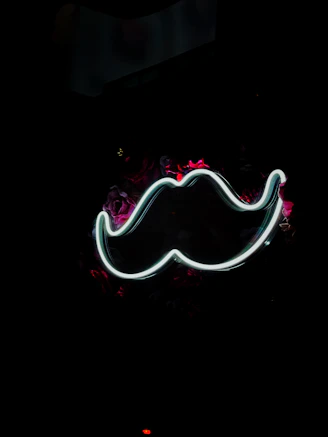 a neon moustache on a black background