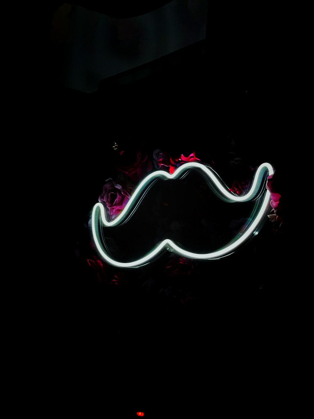 a neon moustache on a black background