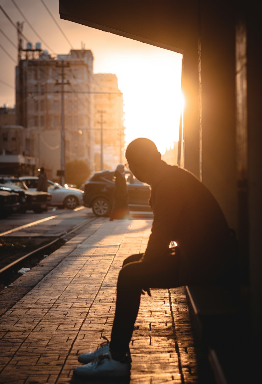 a man sitting on a bench on a city street