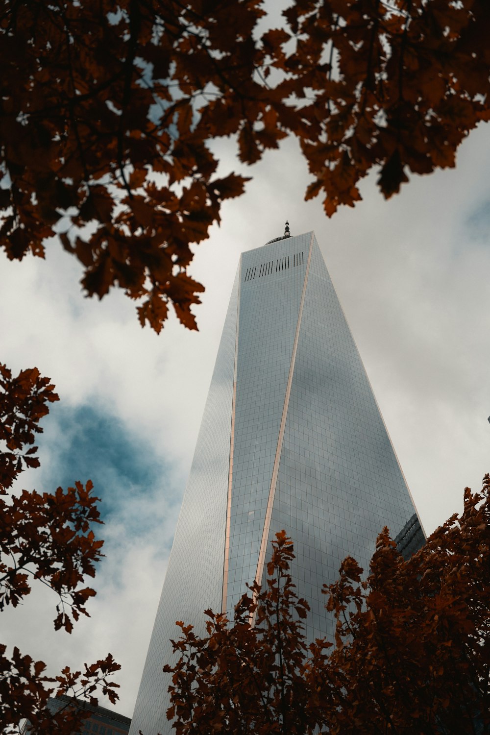 a tall building surrounded by trees and clouds