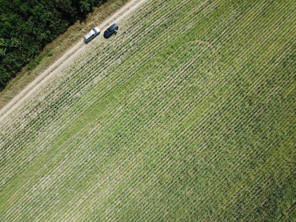 an aerial view of a farm field with two tractors