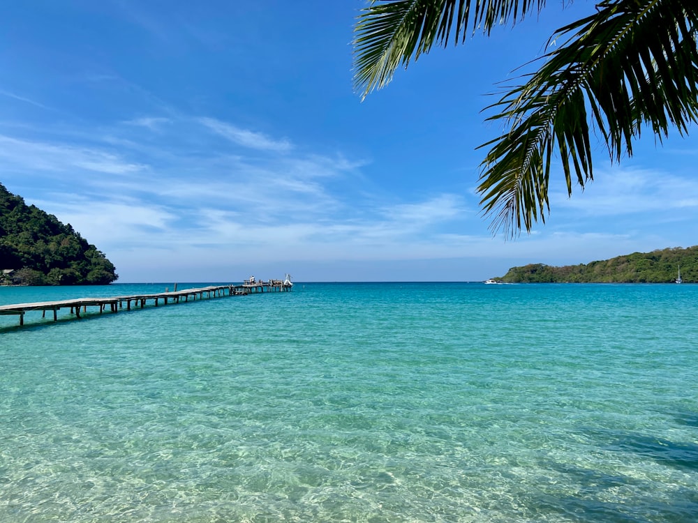 a long pier stretches out into the ocean